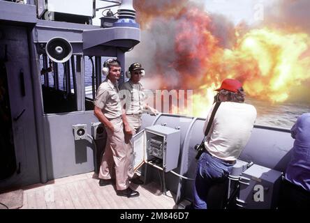 William Snyder, photographe de Dallas 'Morning News', prend une photo informelle du CAPT. John J. Chernesky est parti, officier de guerre du cuirassé USS IOWA (BB-61), et CAPT. Gerald E. Gndow, commandant, utilisant comme toile de fond un salvo à canon unique de la tourelle n° 2. Pays : inconnu Banque D'Images