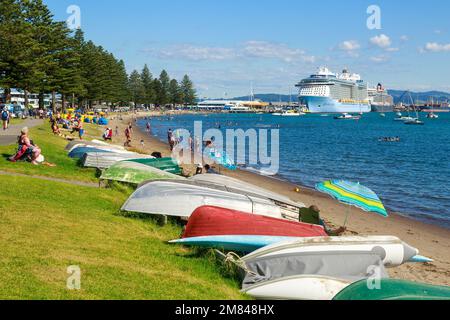 Mont Maunganui, Nouvelle-Zélande, en été. Vue sur la plage de Pilot Bay, avec deux grands bateaux de croisière dans le port Banque D'Images