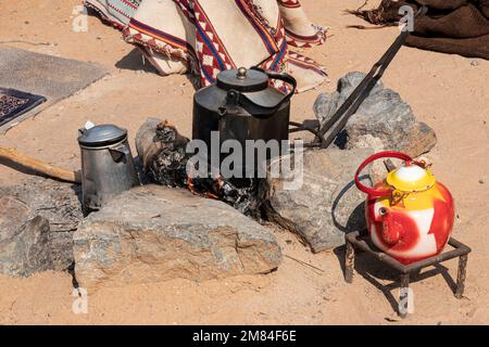 feu de camp avec une bouilloire de fer dans le désert. faire du thé ou du café pendant une pause-camping. Banque D'Images