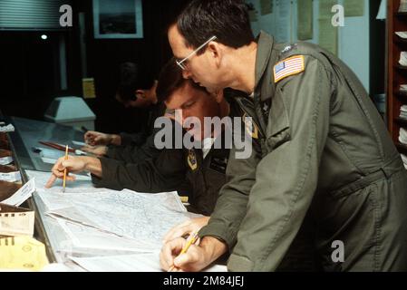 De droite à gauche, MAJ. Victor Hooper, LT COLONNE Richard Evans et LE CAPT. Kenneth Riley, de l'escadron de transport aérien militaire 68th, calcule l'information de vol avant de partir de la base. Le 68th MAS a transporté des fournitures et de l'équipement à la base aérienne. Base: Yokota Air base pays: Japon (JPN) Banque D'Images