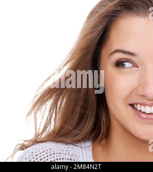 Naturellement beau. Une jeune femme souriant et regardant latéralement sur un fond blanc. Banque D'Images