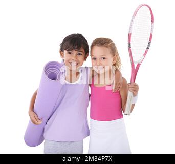 Marcher sur les traces de nos passe-temps préférés de mamans. Portrait de deux petites filles dans des vêtements de sport debout côte à côte isolé sur blanc. Banque D'Images