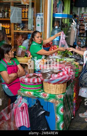 Une femme vend des produits frais au marché Benito Juarez, dans le centre historique d'Oaxaca, au Mexique. En face est une femme qui vend des chapulines ou des g rôtis Banque D'Images