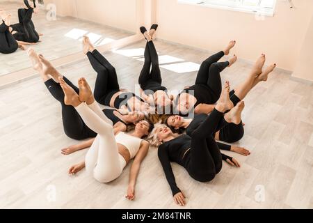 Sept femmes heureuses se trouvent sur le dos, sur le sol, la tête étant pressée. Banque D'Images