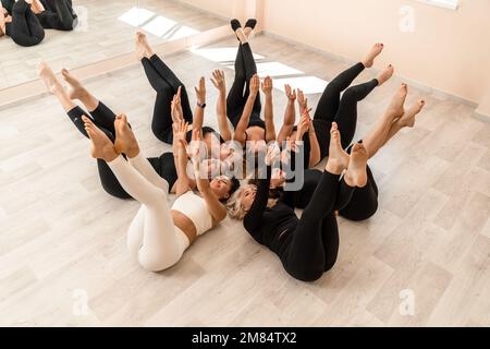 Sept femmes heureuses se trouvent sur le dos, sur le sol, la tête étant pressée. Banque D'Images