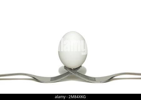 Oeuf debout sur deux fourches Banque D'Images