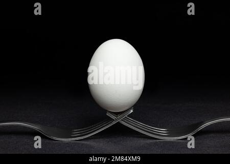 Oeuf debout sur deux fourches Banque D'Images
