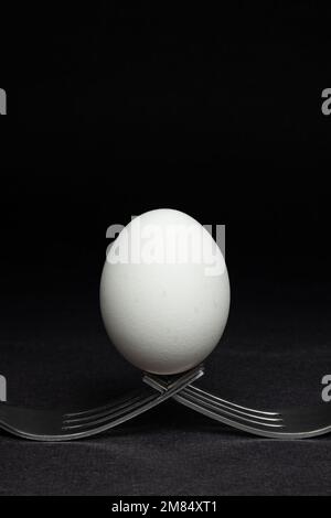 Oeuf debout sur deux fourches Banque D'Images