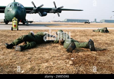 Les membres de l'escadre tactique de 435th (435th TAW) font des victimes après une simulation d'attaque près d'un aéronef C-130E Hercules de l'escadron de transport aérien tactique 37th. Les aviateurs, équipés d'engins de guerre nucléaire-biologique-chimique, participent à l'exercice de manœuvres en voilier, conçues pour tester l'état de préparation opérationnelle des 435th TAW et des organismes locataires de l'aile. Objet opération/série: BLUETAIL base: Aviano Air base État: Pordenone pays: Italie (ITA) Banque D'Images