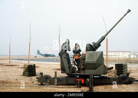 Les membres du Groupe d'artillerie italien de 21st, batterie anti-avion, sécurisent leurs masques à gaz avant de tirer un pistolet anti-avion de 40mm L/70. Le personnel militaire italien participe à l'exercice de manœuvres en voilier, conçu pour tester l'état de préparation opérationnelle de l'aile du transport aérien tactique de 435th et des organisations locataires de l'aile. Objet opération/série: BLUETAIL base: Aviano Air base État: Pordenone pays: Italie (ITA) Banque D'Images