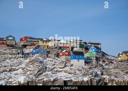 Maisons colorées accrochant sur le flanc de la montagne à Uummannaq dans l'ouest du Groenland Banque D'Images