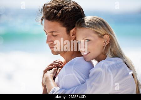 Profitez d'une escapade romantique. Un jeune couple ayant un moment intime sur la plage. Banque D'Images