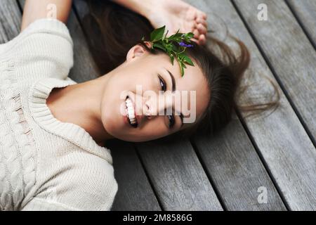 Rempli d'énergie naturelle positive. Une jeune femme attrayante couché sur son porche. Banque D'Images