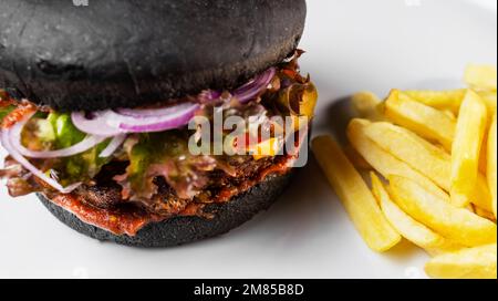 Hamburger noir et pommes de terre frites Banque D'Images