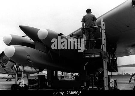 Le personnel d'entretien des munitions sécurise les missiles de croisière à air AGM-86B sur le pylône d'aile à bord d'un B-52G Stratofortress. Base: Griffiss Air Force base État: New York (NY) pays: Etats-Unis d'Amérique (USA) Banque D'Images