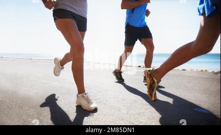 Courir est un mode de vie. Vue à angle bas d'un coureur à côté de l'océan. Banque D'Images