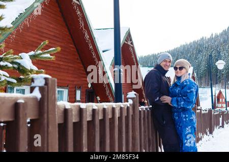 Photo portrait d'un couple joyeux ensemble dans une station d'hiver enneigée Banque D'Images