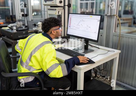 Ingénieur assis dans la salle électronique du robot utiliser l'ordinateur de créer le processus analogique et le diagramme logique Banque D'Images