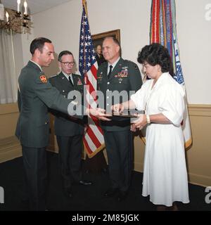 Mme Brenda Schwarzkopf décroche un insigne de rang trois étoiles d'un cas offert par l'Adjudant-CHEF 3 John L. Drummond, à gauche, comme elle et le général Maxwell R. Thurman, deuxième de gauche, Vice-CHEF d'ÉTAT-MAJOR, Armée des États-Unis, Préparez-vous à épingler les étoiles sur les épaules du lieutenant-général H. Norman Schwarzkopf lors de sa cérémonie de promotion au Pentagone. Base: Arlington État: Virginia (va) pays: Etats-Unis d'Amérique (USA) Banque D'Images