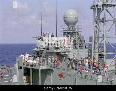 Les membres de l'équipage se tiennent à bord de la frégate australienne de missiles guidés HMAS SYDNEY (FFG-03) lors d'un exercice de reconstitution en cours avec le porte-avions à propulsion nucléaire USS CARL VINSON (CVN-70). Derrière lui se trouve le Mark 16 Phalanx dans le système d'armes. Pays : Océan Pacifique (POC) Banque D'Images