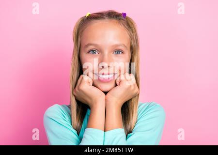 Gros plan photo de jeune petite petite jolie écolière sourire touchante joues rêveur look vous apprenant positif étudiant isolé sur fond de couleur rose Banque D'Images