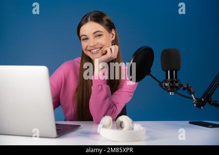 Adolescent regardant la caméra près des appareils et du microphone isolés sur le bleu Banque D'Images