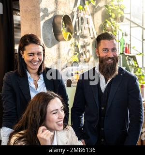 Collègues riant ensemble pendant une pause dans le bureau moderne - élégant homme d'affaires hippster plaisantant avec des collègues multiethniques sur le lieu de travail Banque D'Images