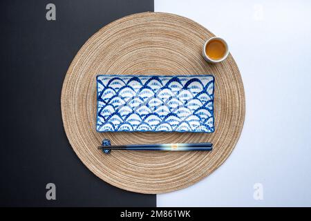 Table japonaise ou chinoise avec tapis de table traditionnel et vaisselle avec arrière-plan et fond blanc. Concept de restauration. Pose à plat. Banque D'Images