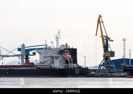 Riga, Lettonie - 9 février 2021 : navire de cargaison en vrac sous pont-grue portuaire Banque D'Images
