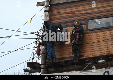 Erkelenz, Allemagne. 12th janvier 2023. Les activistes du climat se tiennent sur une hutte en bois dans le village occupé de Lützerath. La société d'énergie RWE veut fouiller le charbon situé sous Lützerath - à cette fin, le hameau sur le territoire de la ville d'Erkelenz à la mine de lignite opencast Garzweiler II doit être démoli. Credit: Henning Kaiser/dpa/Alay Live News Banque D'Images