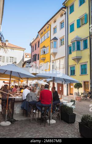 Bar Bolzano, vue sur les personnes se détendant aux tables à l'extérieur d'un bar dans une rue dans le centre historique de la vieille ville de Bolzano, Italie Banque D'Images