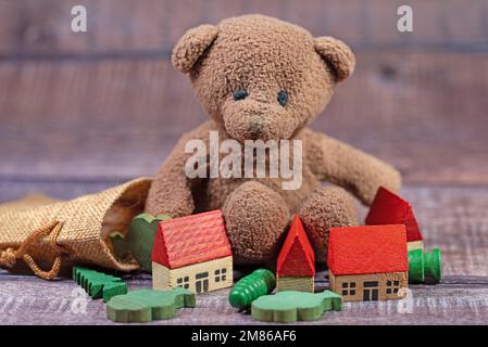 Ours en peluche et jouet en bois devant un fond blanc Banque D'Images