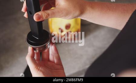 femme tenant un porte-filtre et un café pressé, paquet de café en arrière-plan. Photo de haute qualité Banque D'Images