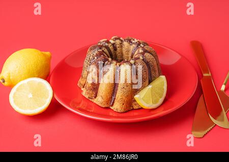 Assiette de délicieux gâteaux et citrons sur fond rouge Banque D'Images
