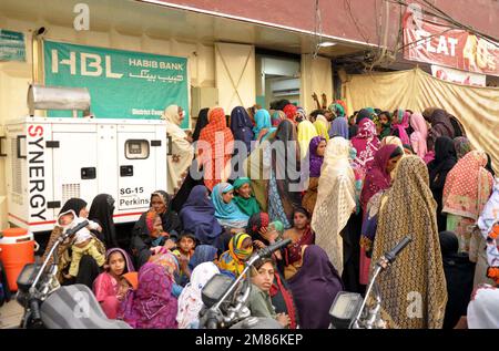 Hyderabad, Pakistan, 12 janvier 2023. Un grand nombre de femmes pauvres bénéficiaires du Programme de soutien du revenu Benazir Bhutto (BISP) se réunissent à leur tour pour obtenir de l'argent au Centre de collecte BISP, au Centre Gul à Hyderabad jeudi, 12 janvier 2023. Banque D'Images