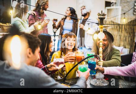 Les gens branchés qui aiment prendre un cocktail au bar shisha - des amis de l'âge se sont mis à vous pour siroter un verre dans le jardin du restaurant chic - Dine an Banque D'Images