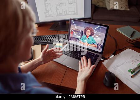 Une femme méconnaissable parle avec un client par appel vidéo en ligne depuis son bureau à domicile Banque D'Images