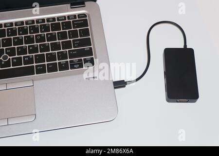 concentrateur usb-c connecté au port d'un ordinateur portable isolé sur fond blanc Banque D'Images