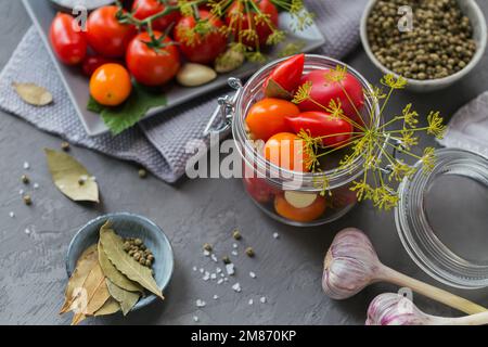 Mise en conserve maison. Ingrédient pour les tomates de cornichon avec l'aneth sur une table de cuisine. Salades de légumes pour l'hiver. Banque D'Images