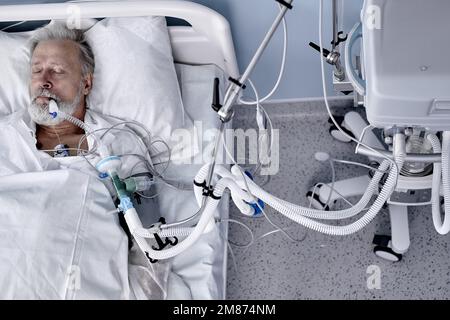 Malade caucasien senior patient est sur le lit dans l'hôpital moderne, saline perfusion intraveineuse sur la main. coronavirus, covid-19, médecine, concept de santé. Virus Banque D'Images