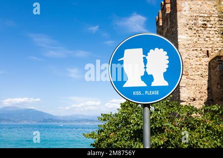 Panneau rue KISS situé dans la zone publique en face du château de Sirmione, Italie. Concept d'amour, couple, romantique Banque D'Images