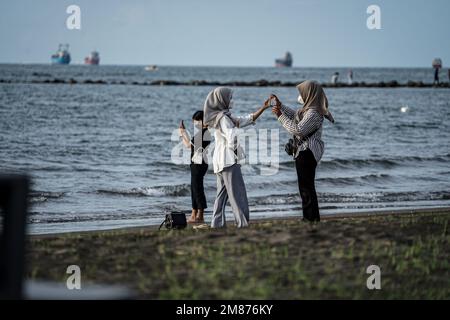 Makassar, Sulawesi du Sud, Indonésie. 12th janvier 2023. Un certain nombre de touristes visitent Pantai Indah Bosowa dans la ville de Makassar, en Indonésie pour profiter de la plage au coucher du soleil. Ce lieu touristique est de plus en plus visité par des touristes de diverses régions du Sud Sulawesi. (Credit image: © Herwin Bahar/ZUMA Press Wire) USAGE ÉDITORIAL SEULEMENT! Non destiné À un usage commercial ! Banque D'Images