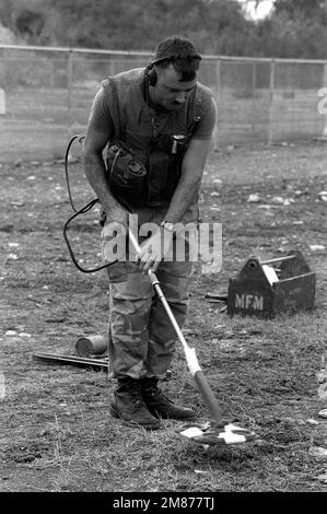 PERSONNEL SGT. Edwin Morehouse, Marine Barracks Minefield Maintenance Section, utilise un détecteur de mines métalliques pour localiser les mines anti-chars sous le sol pendant la formation à un champ de mines. Base : Station navale, Baie de Guantanamo pays : Cuba (CUB) Banque D'Images