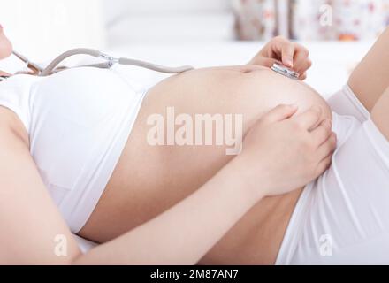 Les femmes enceintes portent un stéthoscope pour écouter le fœtus Banque D'Images