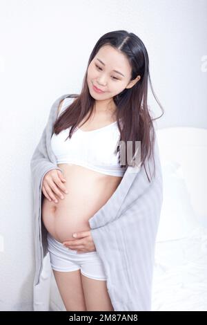 Femmes enceintes portant une couverture fine à la maison