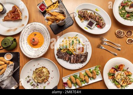 Encore une vie de plats délicieux avec des recettes et des salades espagnoles, croquettes de jambon serrano, steak d'entrecote cuit au charbon de bois, fleur d'artichaut frit et Banque D'Images