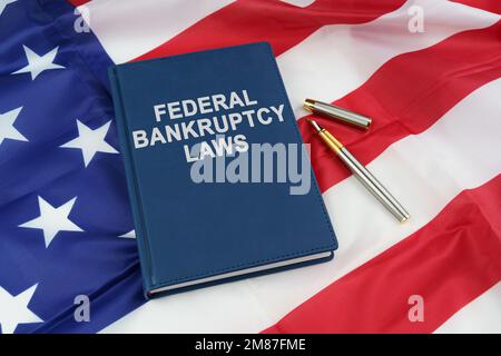 Concept de droit. Sur le drapeau américain se trouve un stylo et un livre avec l'inscription - LOIS FÉDÉRALES SUR LES FAILLITES Banque D'Images
