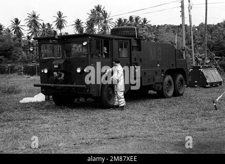 Un pompier de la Force aérienne vêtu d'un costume de proximité parle à un autre aviateur assis dans la cabine d'un camion de sauvetage et de lutte contre les incendies P-4 près de la piste de l'aéroport Melville Hall pendant l'exercice Camille. Les aviateurs sont affectés à l'aile de transport aérien militaire de 437th, qui est basée à la base aérienne de Charleston, S.C. Sujet opération/série: CAMILLE pays: Djibouti (DJI) Banque D'Images