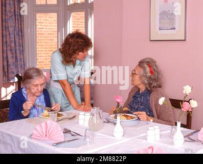 Les résidents d'un sureau mangent un dîner dans le salon de la maison de soins infirmiers, Surrey, Angleterre, Royaume-Uni Banque D'Images