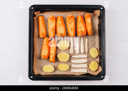 Légumes rôtis sur la plaque du four Citrouille, pomme de terre et racine de panais. Végétarien, nourriture saine. Vue de dessus, plan d'agencement. Banque D'Images